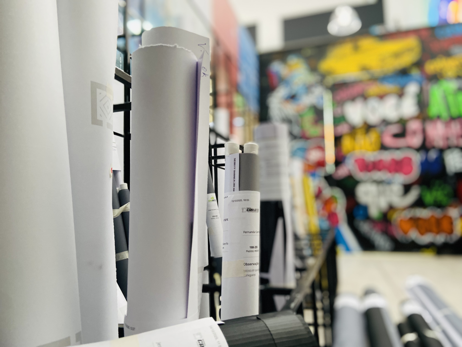 Materiais em rolo organizados no setor de produção da Criarte