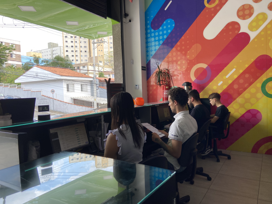 Equipe da Criarte trabalhando em computadores na área de atendimento e criação