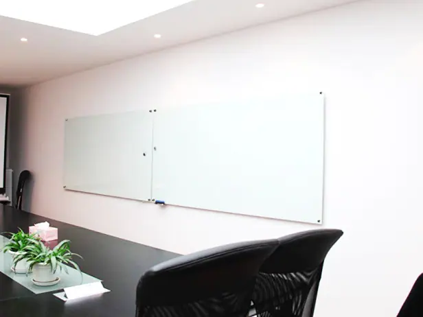 Lousa de vidro sob medida instalada em ambiente comercial ou corporativo.