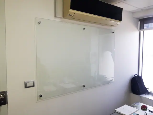 Lousa de vidro sob medida instalada em ambiente comercial ou corporativo.