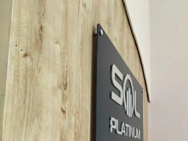 Placa de vidro com letras 3D instalada em ambiente comercial ou corporativo.